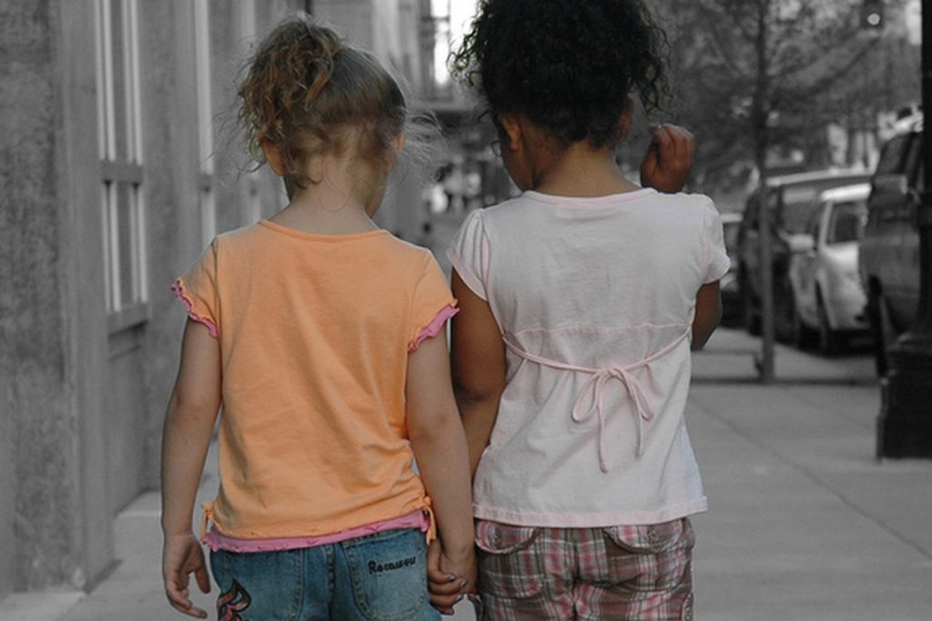 Two little girls hold hands